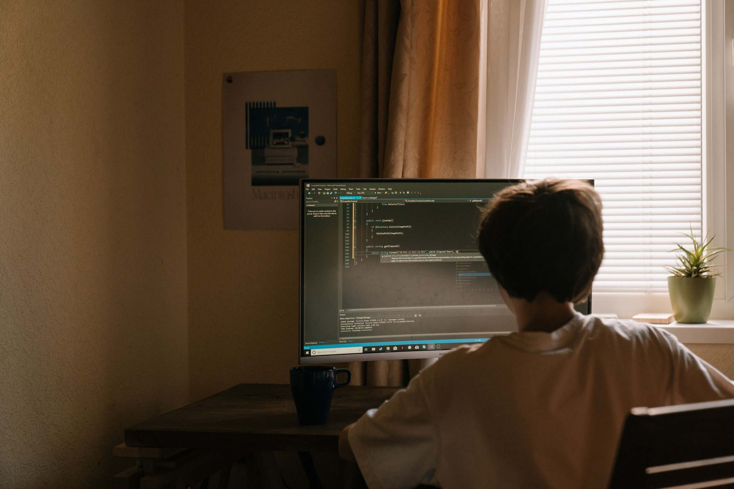 Wide view of a software developer workspace with monitors at a home desk